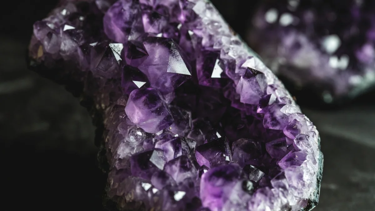 Interior de geodo de ametista com cristais roxos brilhantes em close detalhado.